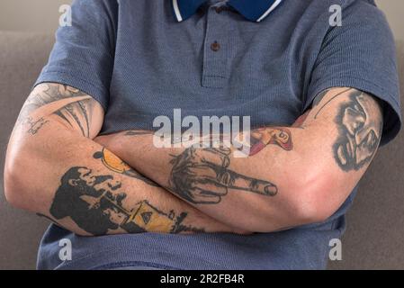 Crossed, tattooed arms of a young man, Bavaria, Germany Stock Photo