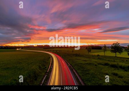 Long exposure of federal road 2 at Germering in the evening mood with traces of light from the moving vehicles. Germering, Upper Bavaria, Bavaria, Ger Stock Photo