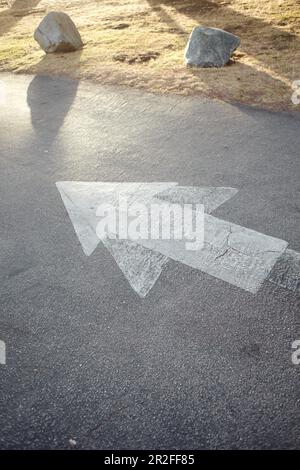 Arrows on the pavement in a parking lot in the evening light near Big Sur, California, USA. Stock Photo