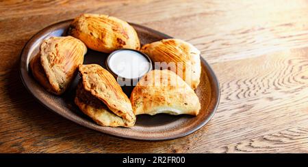 A plate of oven-baked pierogi on a restaurant table Stock Photo