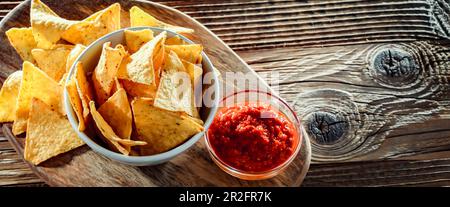 Composition with a bowl of tortilla chips and dipping sauce Stock Photo