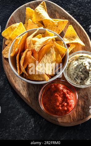 Composition with a bowl of tortilla chips and dipping sauces Stock Photo