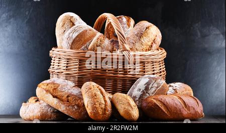 Wicker basket with assorted bakery products including loafs of bread and rolls Stock Photo