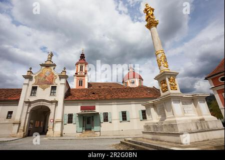 Marian column on the main square with the collegiate church of St. Vitus, Poellau Abbey, Poellau, Styria, Austria Stock Photo