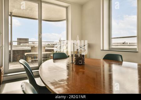 a table and chairs in a room with large windows that look out onto the cityscapea photo taken from inside Stock Photo