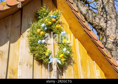 Easter wreath, Easter fountain decorated with colorful Easter eggs in Wohlmuthshüll in Franconian Switzerland, Bavaria, Germany Stock Photo