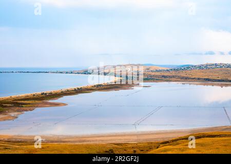 Seascape. The sea is next to the lake, separated by a narrow isthmus from the road. Stock Photo