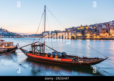 Barcos Rabelos, port wine boats on the Duero River in front of the historic old town of Porto at night, Portugal Stock Photo