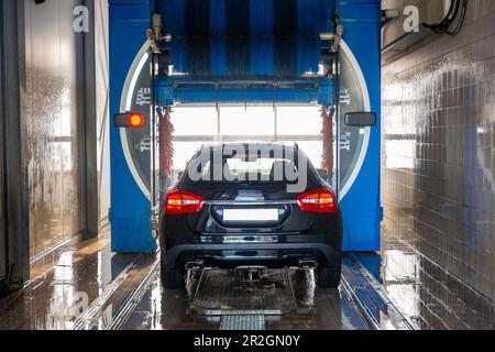 Car in Automatic Car Wash Machine in a Sunny Day in Switzerland. Stock Photo