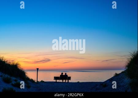 Dune/Badedüne, side island of Helgoland, park bench on the north beach with couple at sunset, lighthouse on dune on the south beach, Heligoland, North Stock Photo