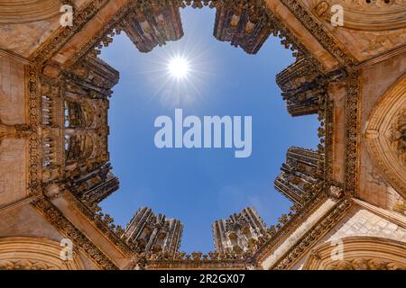Sun star backlit over the magnificent unfinished chapels of Batalha Monastery ultra wide angle, Portugal Stock Photo