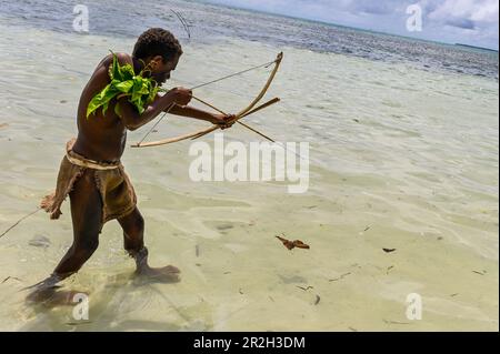 In the Solomon Islands, the arch used for fishing is typically made from locally available materials such as wood, bamboo, or other sturdy plant materials. Skilled fishermen utilize their knowledge of fish behavior and habitat to position themselves strategically, often at fishing grounds known for their abundance of fish. Stock Photo
