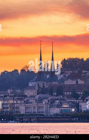 View over Lake Lucerne to Lucerne and the Hofkirche with a red sky Stock Photo