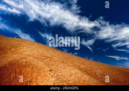 Hikers climbing Ayers Rock, Northern Territory, Australia Stock Photo