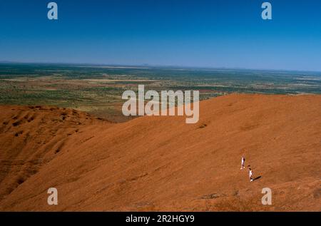 Hikers climbing Ayers Rock, Northern Territory, Australia Stock Photo