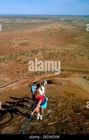 Hikers climbing Ayers Rock, Northern Territory, Australia Stock Photo