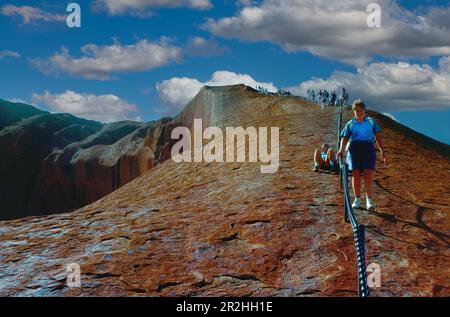 Hikers climbing Ayers Rock, Northern Territory, Australia Stock Photo