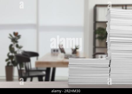 Stacked sheets of paper on wooden table in office, space for text Stock Photo