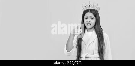 selfishness and egoism. oops. confused egocentric teen girl in crown pointing finger on camera. Child queen princess in crown horizontal poster design Stock Photo