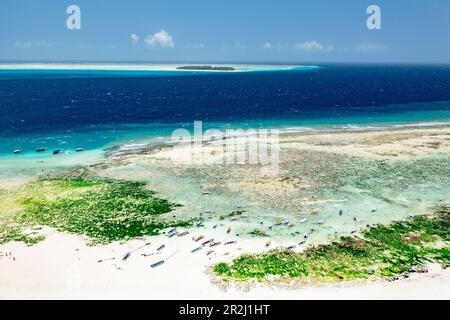 Boats on idyllic sand beach with Mnemba Island in the background, Zanzibar, Tanzania, East Africa, Africa Stock Photo