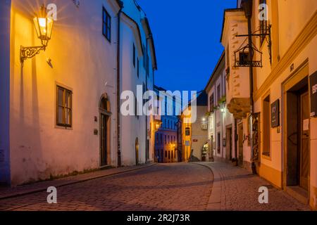 Illuminated street lamp in empty street in historical center at twilight, UNESCO World Heritage Site, Cesky Krumlov, South Bohemian Region Stock Photo