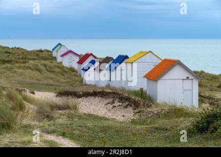 Colorful beach houses in the dunes on the beach at Gouville-sur-Mer, Normandy, France Stock Photo