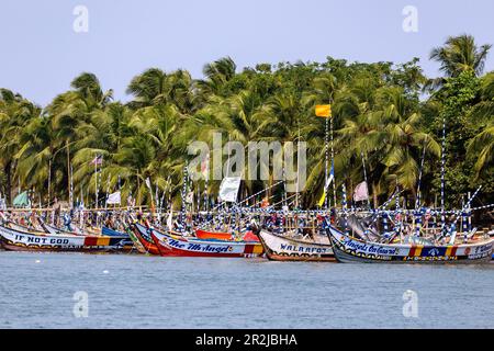 Fishing village of Ada Foah with brightly painted boats on the banks of the Volta River in the Greater Accra region of eastern Ghana in West Africa Stock Photo