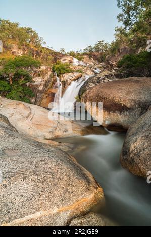 A gorgeous, slow-motion blue-hour image of Emerald Creek Falls captured on a clear evening with some stars in Mareeba, Queensland, Australia. Stock Photo