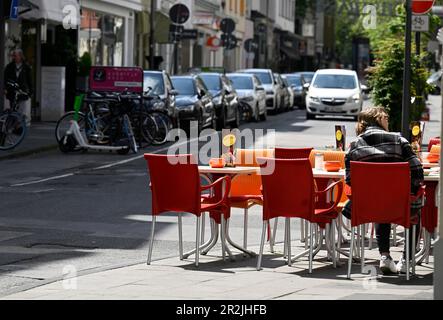 Cologne, Germany. 18th May, 2023. An iced coffee shop has placed its chairs on the sidewalk on Pfeilstrasse. More and more restaurateurs in North Rhine-Westphalia are turning to outdoor catering. They are also using former car parking spaces and sidewalks. Credit: Roberto Pfeil/dpa/Alamy Live News Stock Photo