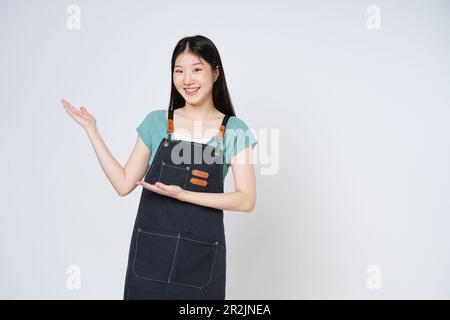 Happy smiling woman chef holding something on palm of hand over white background. Stock Photo