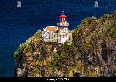 Flowers and cacti in front of a lighthouse by the sea on the island of Sao Miguel, Azores, Portugal Stock Photo