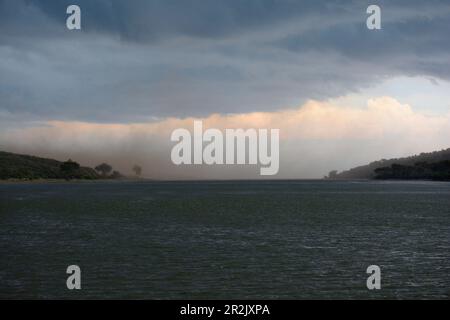 Uganda; Western Region; Queen Elizabeth National Park; Kazinga Canal; just before the confluence with Edward Lake; dark rain clouds over the canal; he Stock Photo