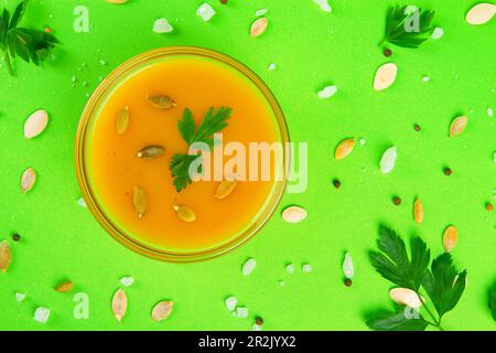 Bowl of tasty pumpkin cream soup on Lush green canvas Stock Photo
