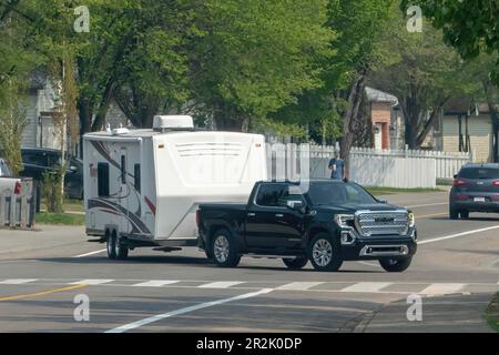 Calgary, Alberta, Canada. May 18, 2023. A black Truck with a white camping trailer RV. Stock Photo