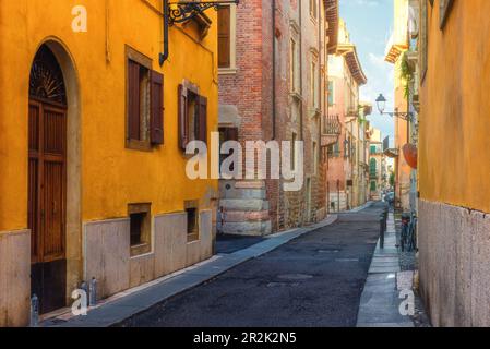 Cozy narrow medieval street with colorful buildings in Verona town, Veneto, Italy, Empty Italian street in old town. Travel destination Stock Photo