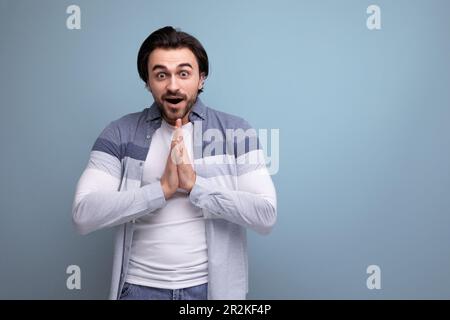 emotional young brutal brunette guy on a studio background for a poster Stock Photo