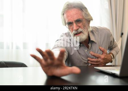 Senior man holding hand on chest and suffering from heart problem Stock Photo