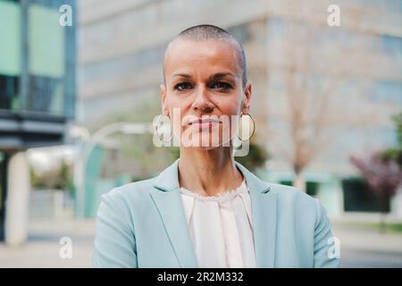 Close up portrait of a successful business woman wearing a formal suit proud of her professional work. One executive female standing at workspace. Confident startup ceo or employee looking at camera. . High quality photo Stock Photo