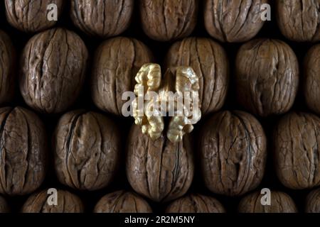 Walnut kernels and cracked walnuts on wooden table Stock Photo