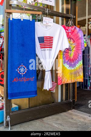 An image of t-shirts and a beach towel on display in a northport store on main street Stock Photo