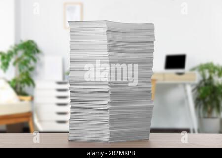 Stacked sheets of paper on wooden table in office Stock Photo