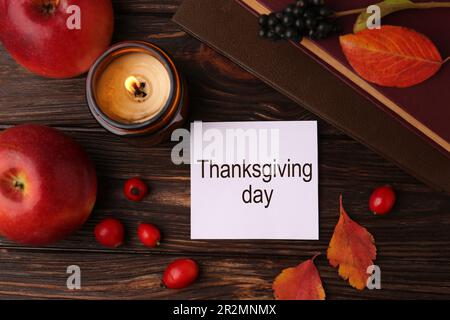 Thanksgiving Day. Flat lay composition with paper card and autumn leaves on wooden table Stock Photo