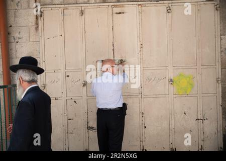 A Palestinian shop owner locks his shop at noon before the Israeli flag march. Tens of thousands participated in the annual Jerusalem Day celebrations, that marks the unification of the city in the 1967 Israel - Arab war. The march passed through Damescus Gate and the Old City. Stock Photo