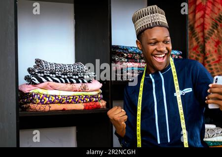 An African man smiling while holding a cell phone Stock Photo