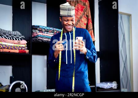 A black african man standing in front of a closet holding a cell phone Stock Photo