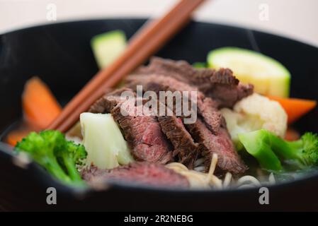Grilled beef Steak and summer vegetable Asian styled Ramen noodle soup bowl. Stock Photo