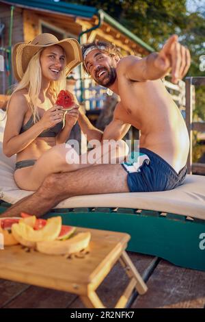 A young couple in love enjoying the view while sunbathing on the river bank on a beautiful summer day. Summer, river, vacation Stock Photo