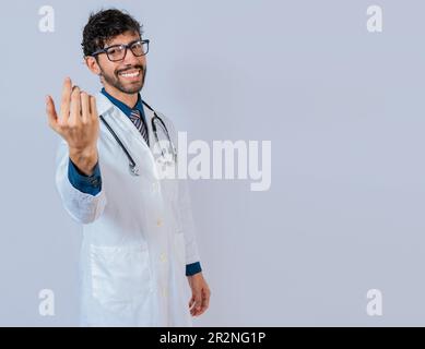 Smiling doctor inviting to come isolated. Young friendly doctor inviting to come on isolated background Stock Photo