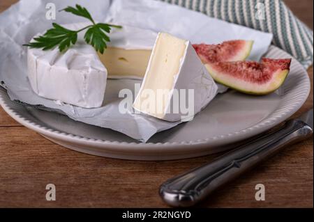 Sliced soft cheese on a plate with figs Stock Photo