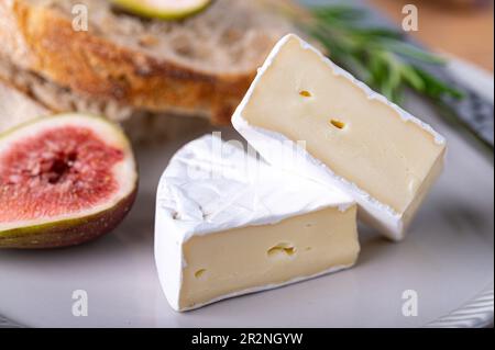 Sliced soft cheese on a plate with figs Stock Photo